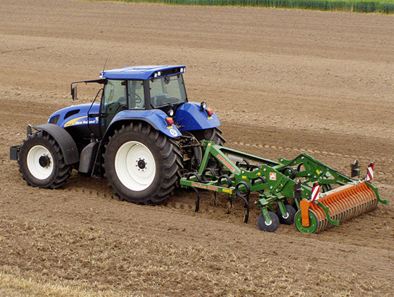 blauer new holland traktor mit amazone pflug im einsatz auf feld