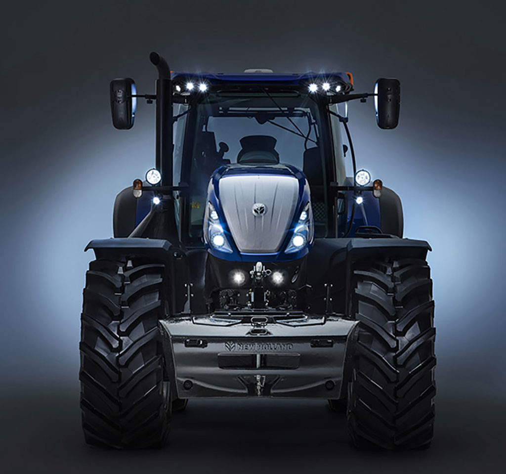 blauer new holland traktor frontansicht mit scheinwerfern an grauer hintergrund